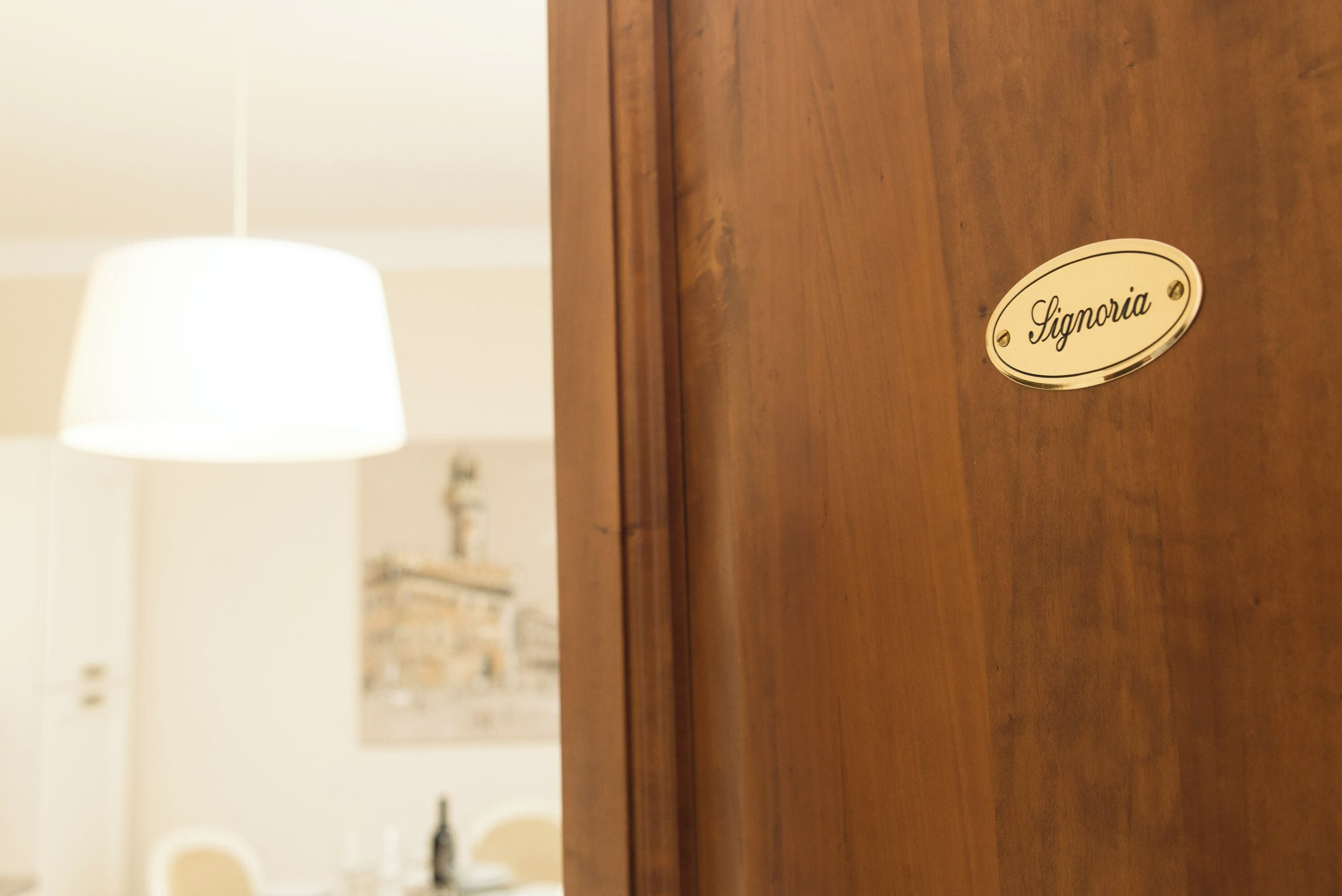 Una puerta de madera con una placa de latón que dice "Signoria".