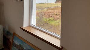 A room with a large arched window overlooking a landscape.