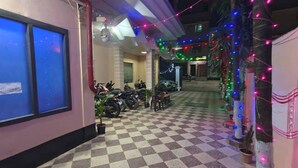 Piso xadrez, motocicletas e um prédio com parede rosa.