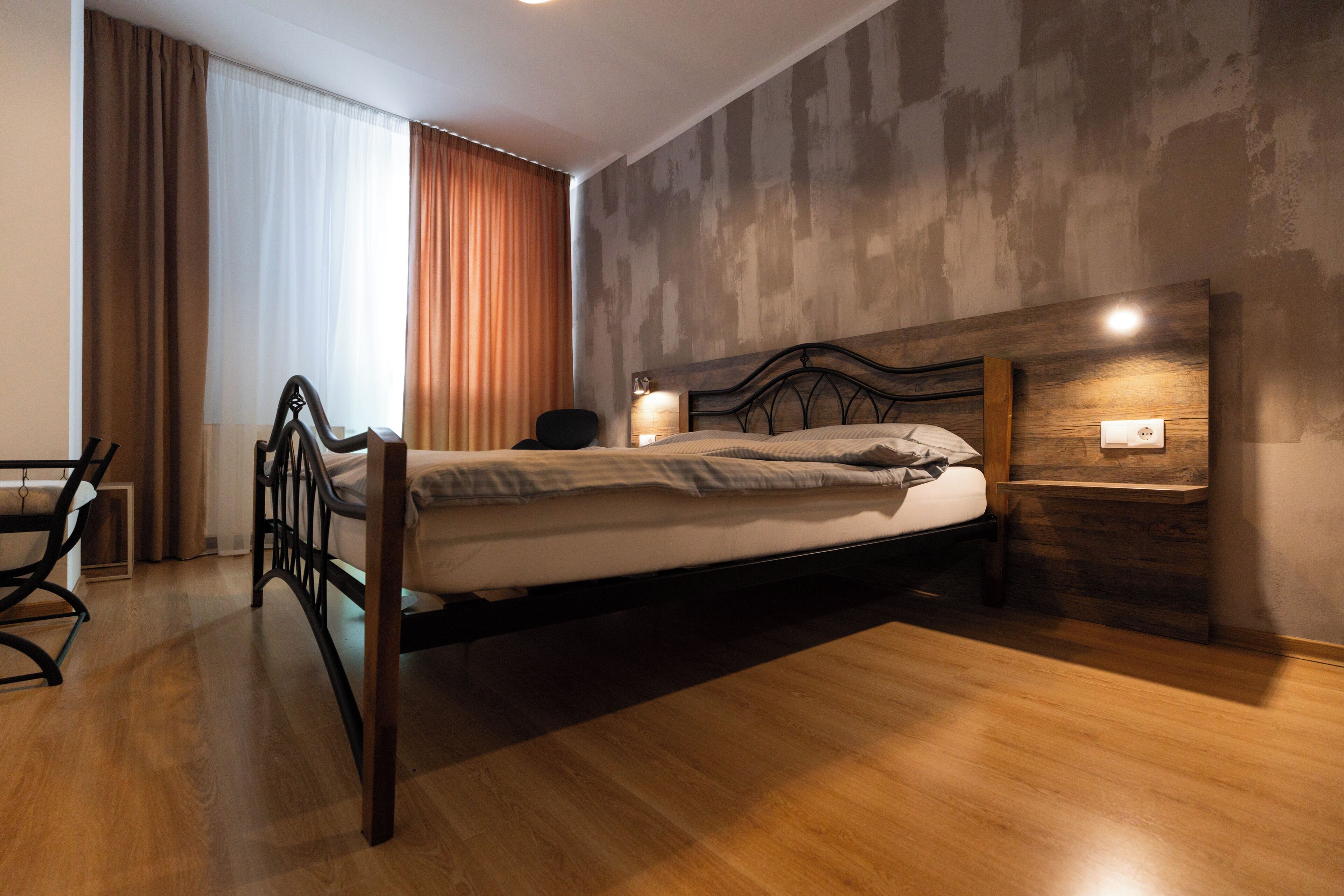 A modern bedroom with a wooden bed, a desk, and a chair.
