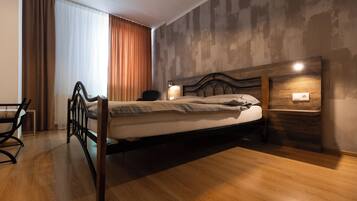 A modern bedroom with a wooden bed, a desk, and a chair.