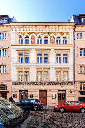 A multi-story building with a classic architectural style, featuring ornate decorations and multiple windows. - Golden Dog Kingdom (Hlavní mesto Praha)