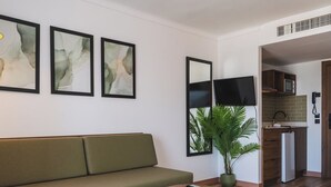 Una sala de estar moderna con un sofá verde, una mesa de centro de madera y arte abstracto en la pared.