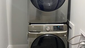 A stacked washer and dryer unit with a digital display and control panel. - Luxurious 2 Bdrm Suite ~ North Edmonton (3min to Anthony Henday/Manning Dr) (Edmonton)