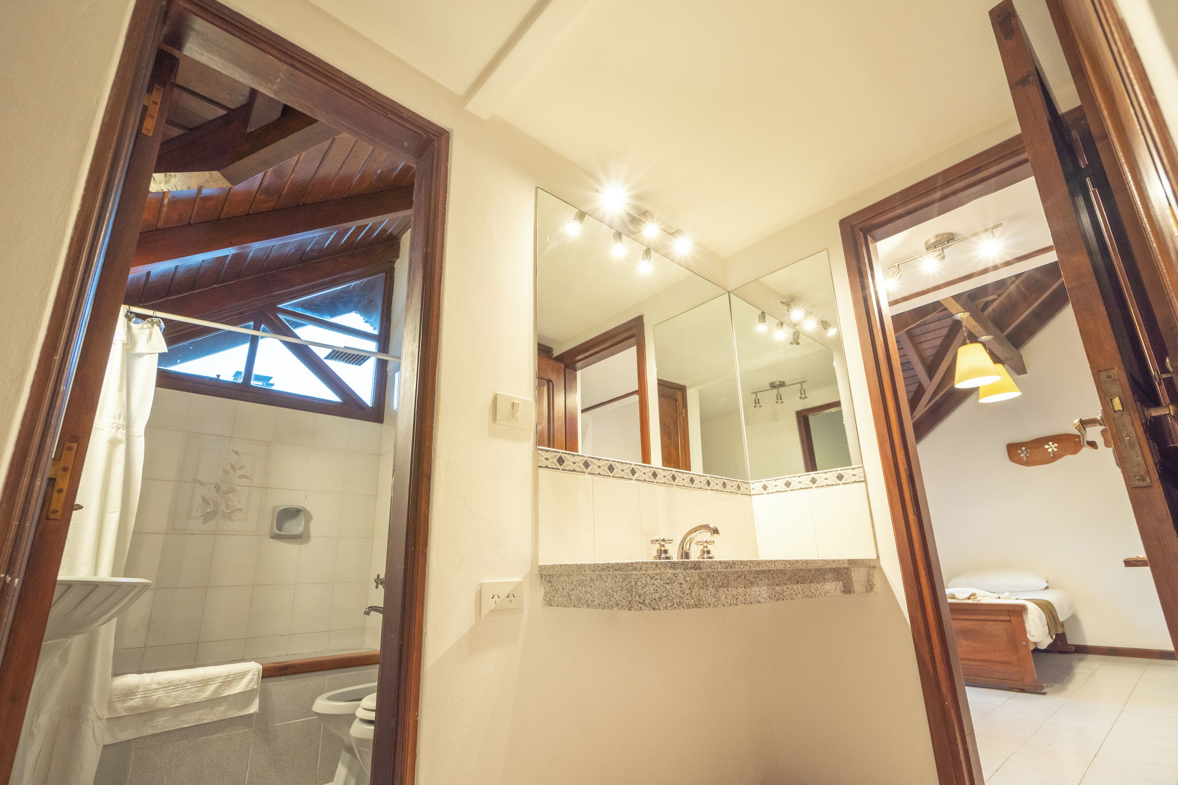 Un bagno con doccia, toilette, lavandino e uno specchio grande.