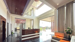Eine geräumige Lobby mit Empfangstresen, einer Sitzecke und Blick ins Freie.