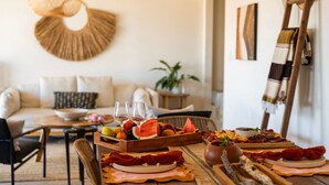 Un coin repas avec une table mise pour le dîner, un canapé en arrière-plan et une échelle appuyée contre le mur.