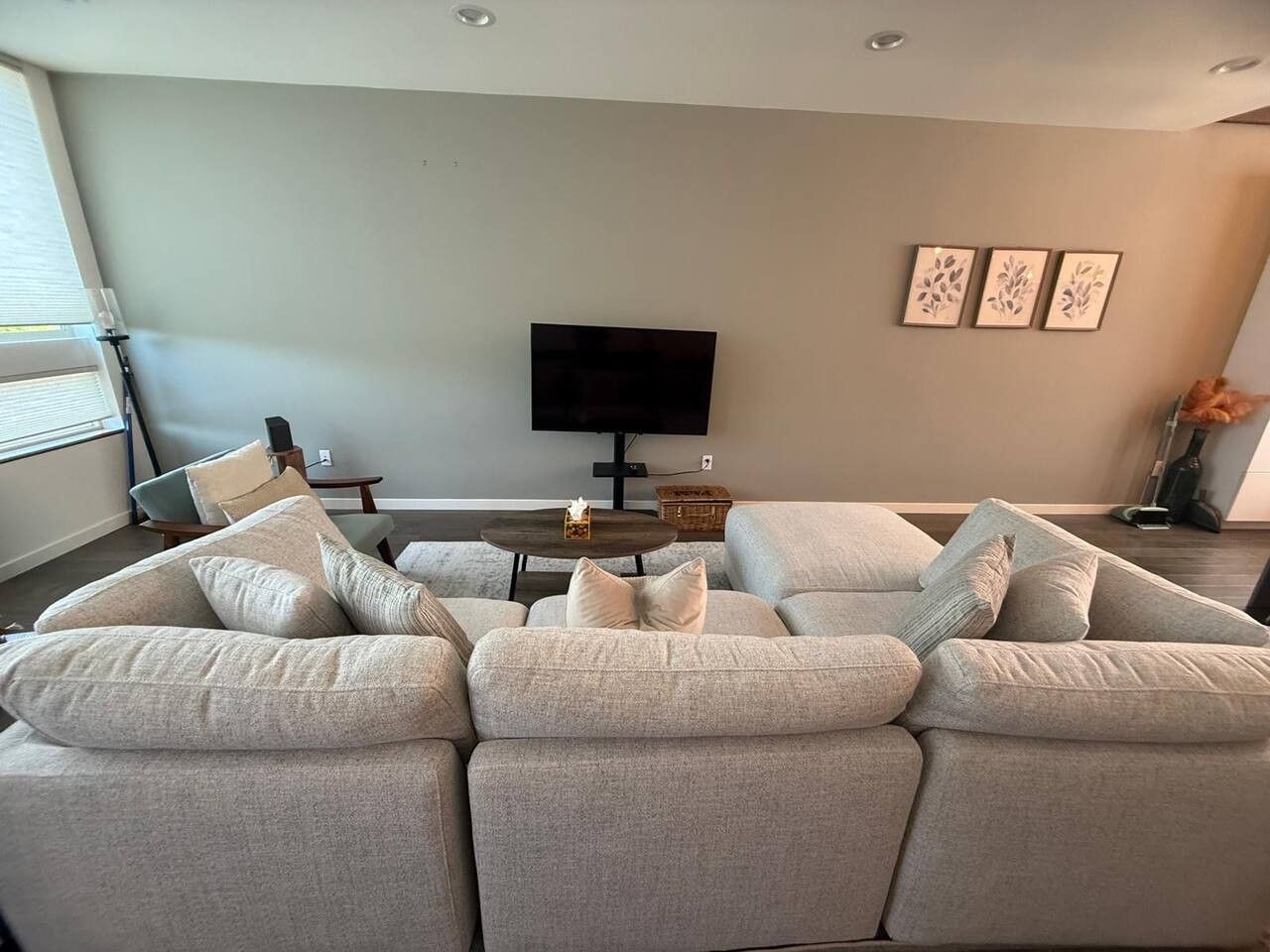 A modern living room with a sectional sofa, a flat-screen TV, and a coffee table.