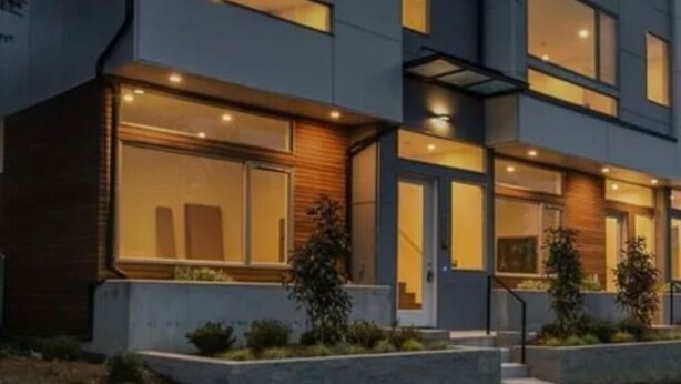A modern multi-story building with large windows and a flat roof.