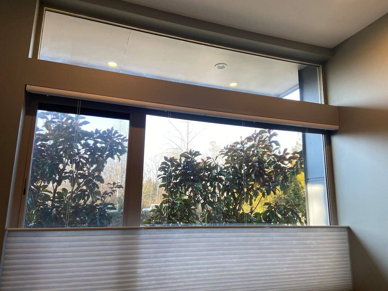 Une pièce avec une grande fenêtre, un luminaire au plafond et un radiateur.