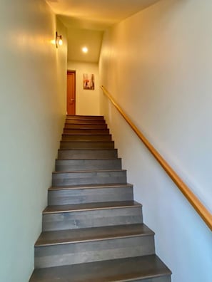 A staircase with a wooden handrail leading to a door at the top. - The Imagination House! (Seattle)