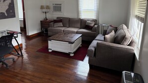 A living room with a sectional sofa, a coffee table, a side table, and a lamp.