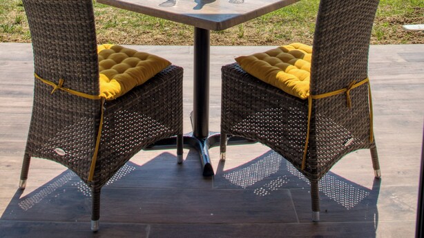 An outdoor seating area with wicker chairs and a table, overlooking a green landscape. - L'Annexe Coté Castagne du Domaine des Hauts de Rouquette (Eymet)