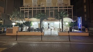 Un hôtel à plusieurs étages, doté de balcons et d’une entrée principale.