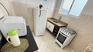 Une cuisine compacte équipée d’un réfrigérateur, d’une cuisinière et d’un four à micro-ondes.
