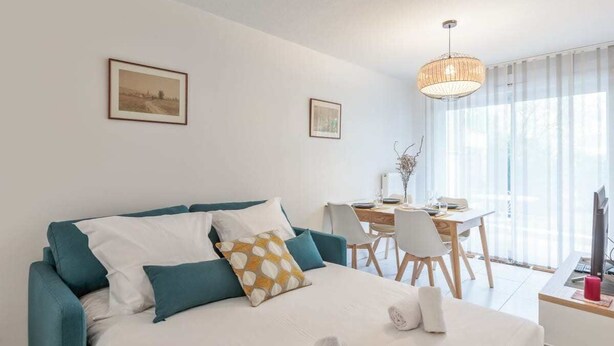 A modern hotel room with a bed, a desk, and a dining area. - Beautiful apartment - near the beach (La Rochelle)