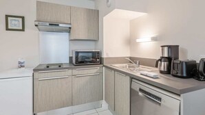 A modern kitchen with light wood cabinets, a microwave, a coffee maker, and a dishwasher. - Beautiful apartment - near the beach (La Rochelle)