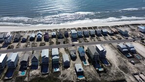 An aerial view of a coastal residential area with houses arranged in rows along a road. - Beach Home With Private Pool & Beach Access- Sleeps 4 (Gulf Shores)