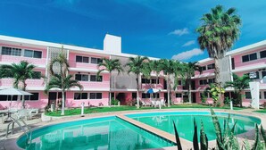 A hotel with a pool, multiple balconies, and palm trees. - Hotel Don Luis  (Valladolid)