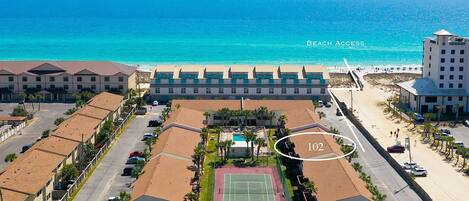 A beachfront hotel with a tennis court, beach access, and a view of the ocean.