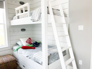 A bunk bed with a ladder, a window, and a small stool. - Beautiful decorated family home on the beach (Galveston)