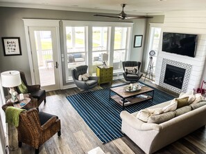 A spacious living room with a fireplace, a large TV, and a comfortable seating area.