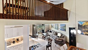 A spacious living area with a kitchen, dining table, and a balcony with wooden railings. - Vail Run 4 Bed room Spring Break Week with Heated Pool, Hot Tub, Sauna (Vail)
