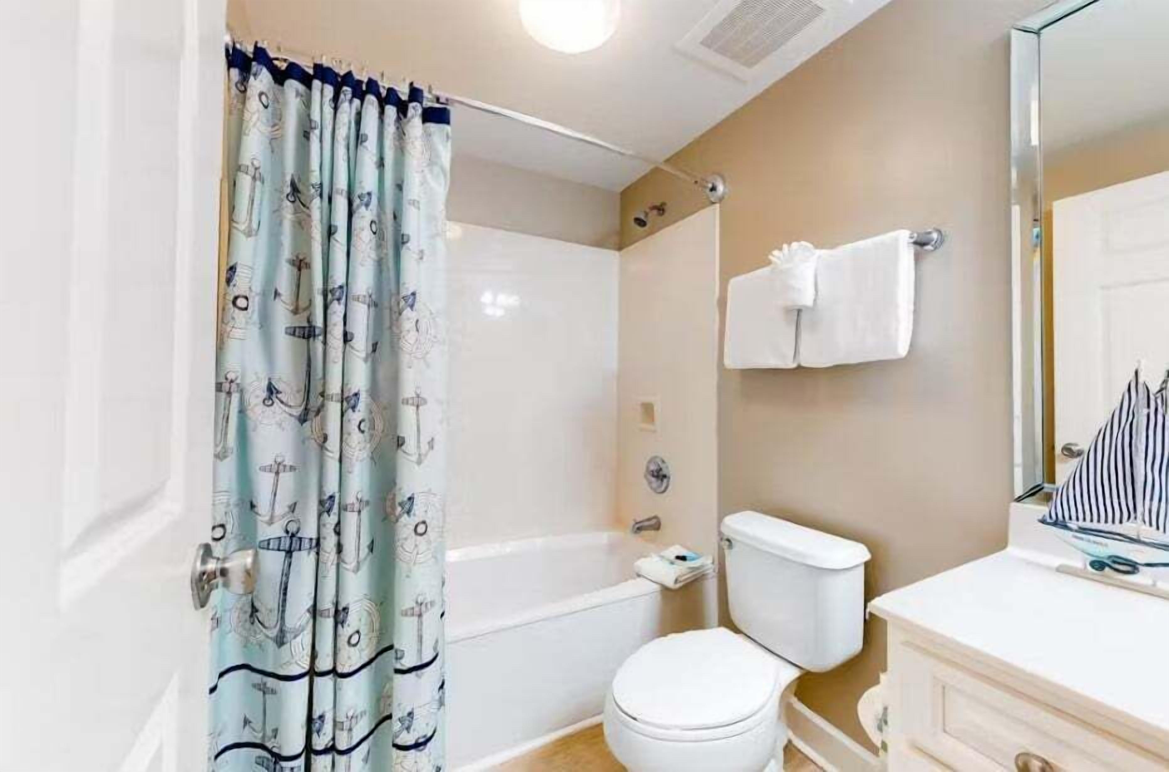 Ein Badezimmer mit Badewanne, Toilette und Spiegel.