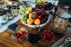 A table with various fruits, berries, and granola jars. - Phakalane Retreat (Cape Town)