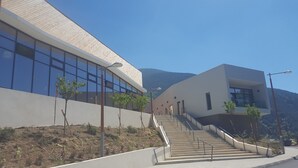 Un edifici modern amb grans finestres i una escala que condueix a l'entrada.
