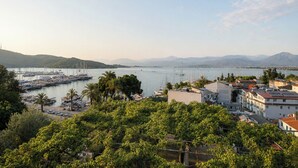 A marina with boats, a hilly landscape, and buildings with visible balconies. - Roof Rooms Fethiye (Fethiye)