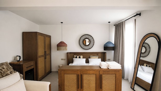 A hotel room with a bed, a wardrobe, a sofa, and a large mirror. - Roof Rooms Fethiye (Fethiye)