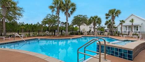 A swimming pool with a 4½ ft depth, surrounded by palm trees and a fence, with a clear blue sky above.