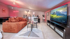 Un salon moderne avec un canapé, une table basse et un téléviseur à écran plat.