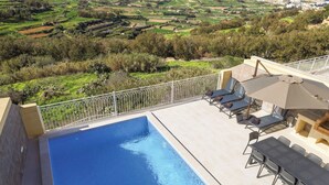 Une piscine sur le toit offrant une vue sur la campagne environnante.