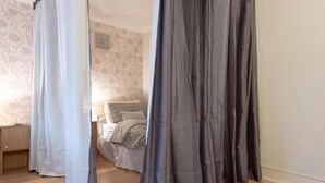 A bedroom with a bed, curtains, and a wooden floor. - 3bedroom Sleeps8 Parking Familyfriendly Nearexcel (London)