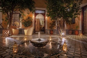 A courtyard with a fountain, lanterns, and potted plants. - RIAD BOHEMIA (Marrakech)