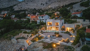 A modern villa with a swimming pool, stone steps, and a landscaped garden.