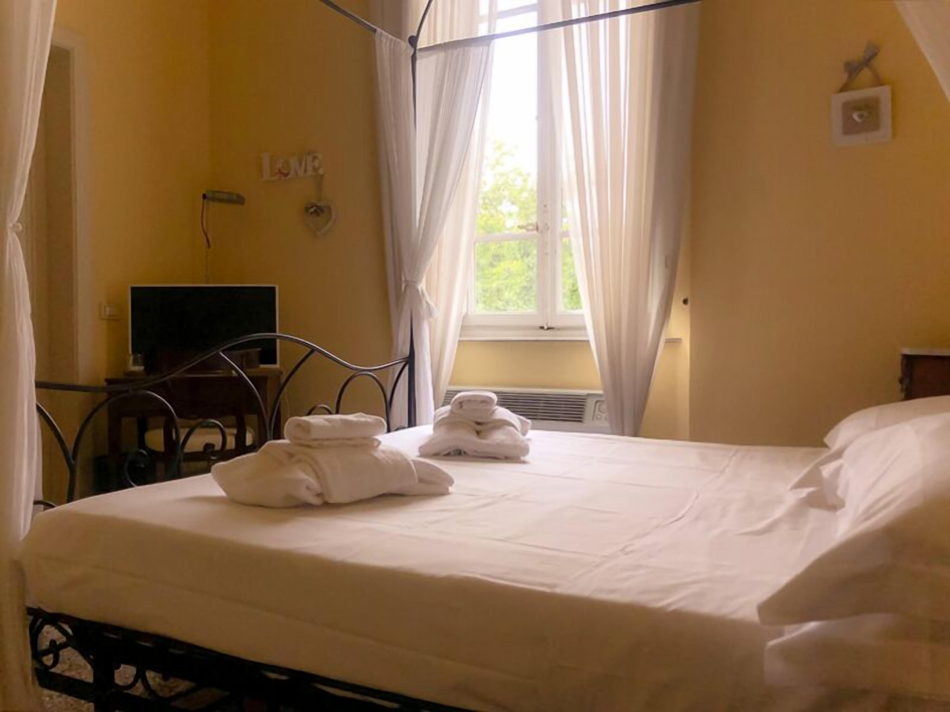 Une chambre à coucher avec un lit, un bureau, une chaise et une fenêtre avec des rideaux.