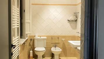 Familie vierpersoonskamer | Badkamer | Een douche, een haardroger, een bidet, handdoeken