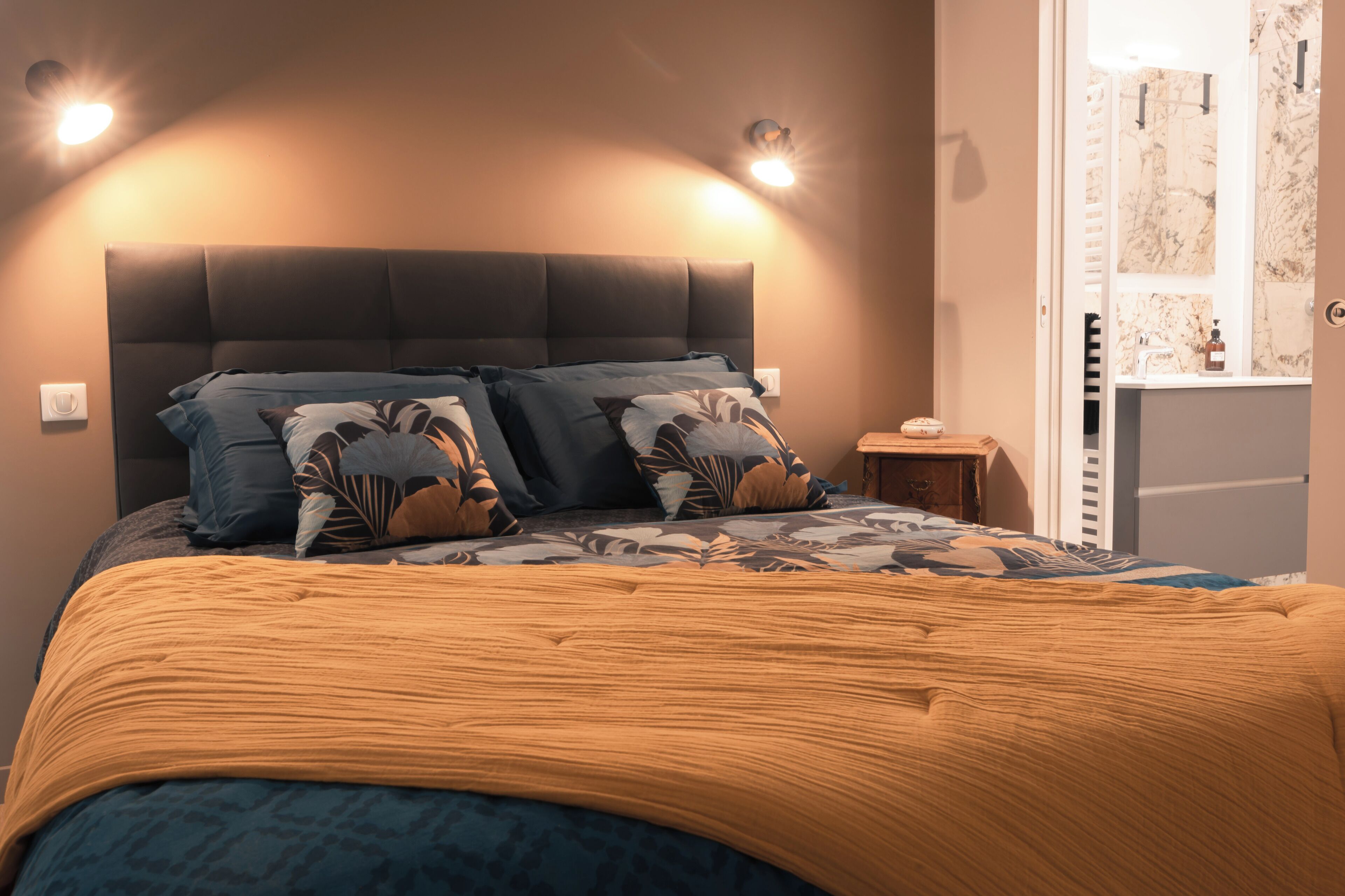A bed with a headboard, two bedside tables, and a nightstand.