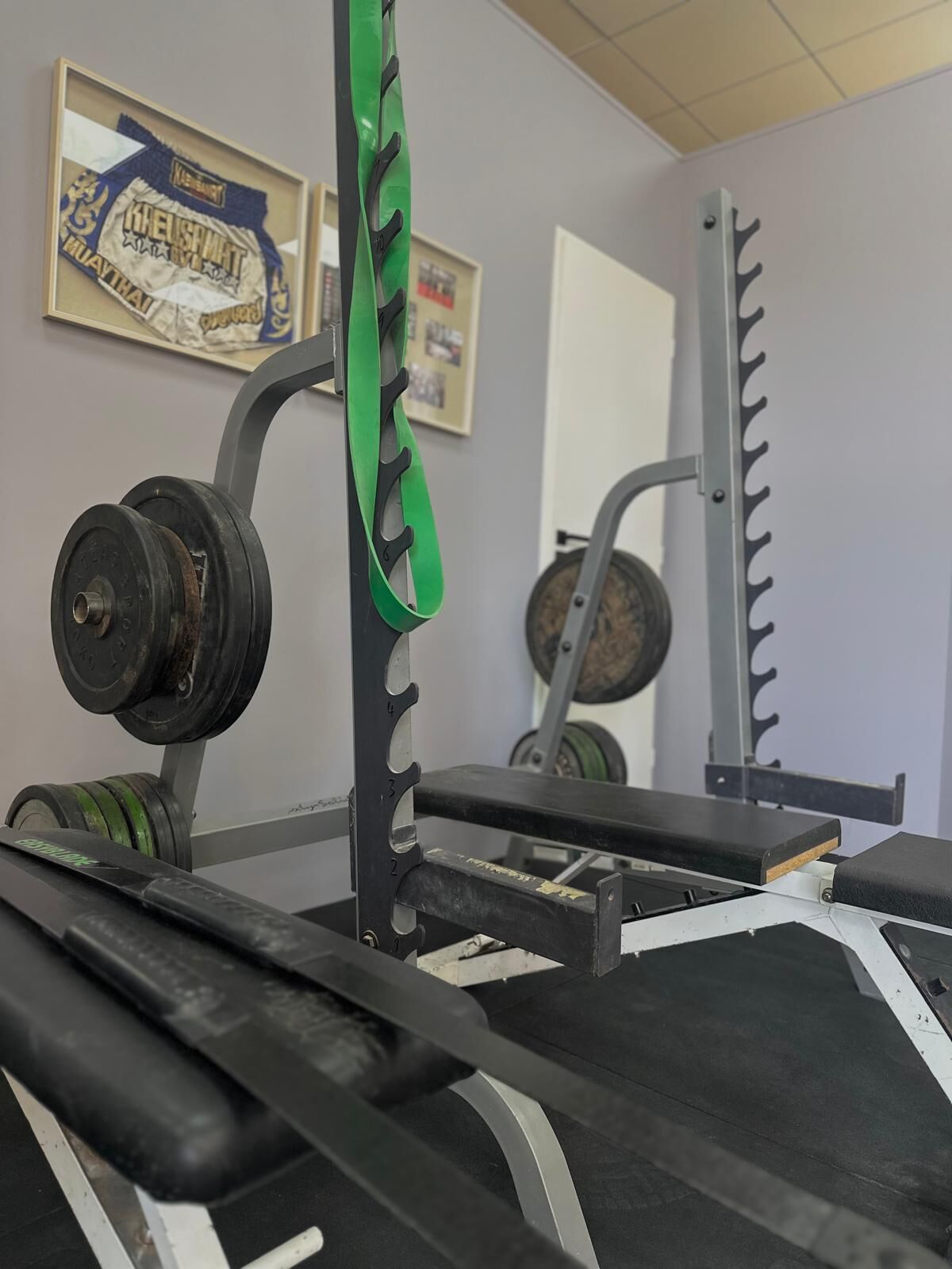 A gym with weightlifting equipment, including a squat rack and barbells.