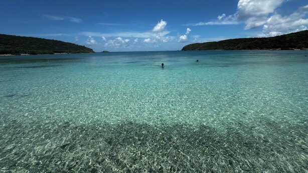 A clear turquoise sea with visible underwater rocks and a distant island. - Thalassa. A Seaside Retreat with Pool & Infinity Oceanfront Sunrise Views (St. John)