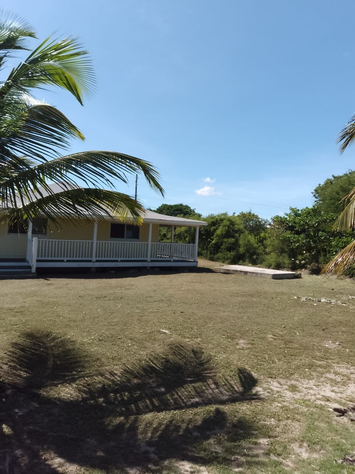 A single-story building with a covered porch and a grassy yard.