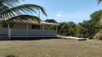 A single-story building with a covered porch and a grassy yard.