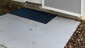 Ein Haus mit weißer Tür und einer kleinen Veranda.