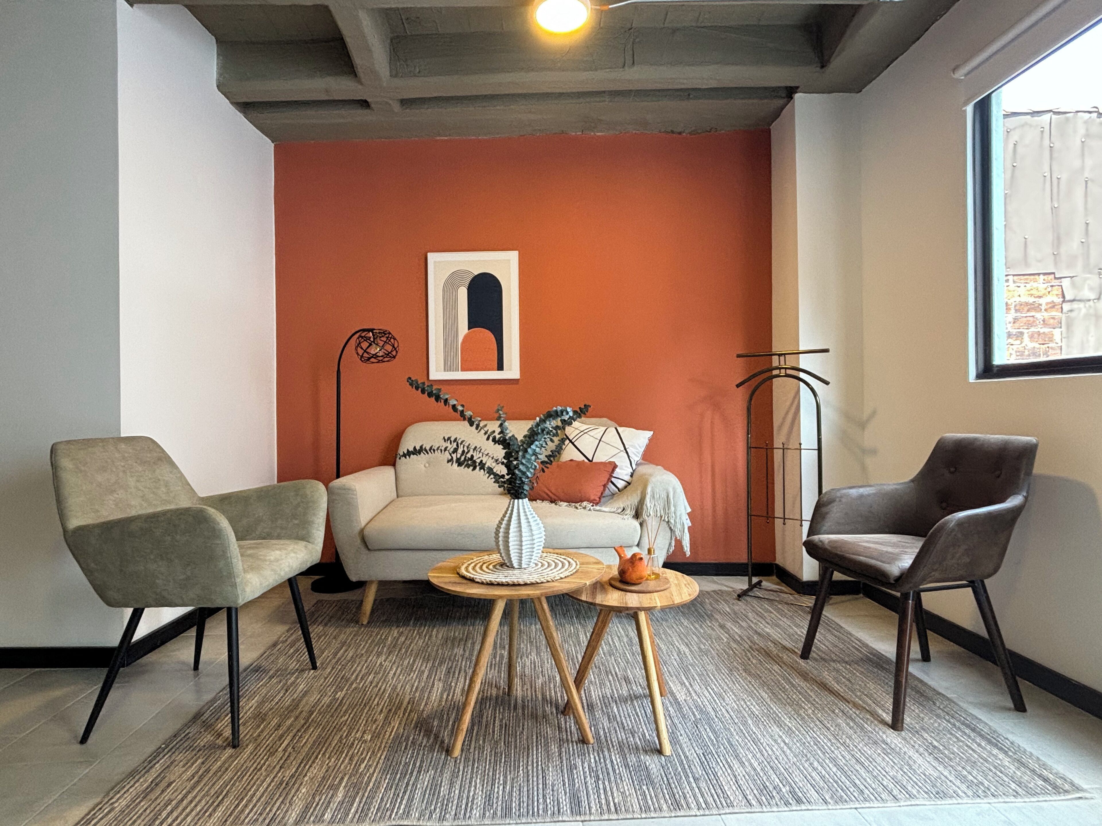 A living room with a sofa, two armchairs, a coffee table, and a floor lamp.
