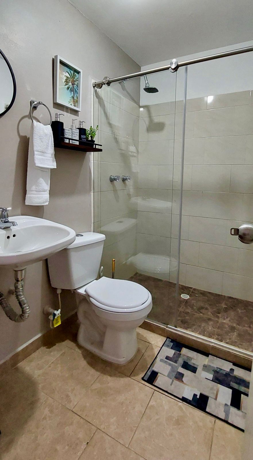 A bathroom with a toilet, sink, and shower.