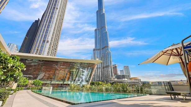 A rooftop pool area with a view of the Burj Khalifa and other modern buildings. - FIRST CLASS | 1BR | Iconic Luxury (Dubai)