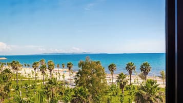 Blick auf die Küste mit Strand, Palmen und blauem Himmel.